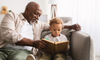 Old man teaching his grandson to read
